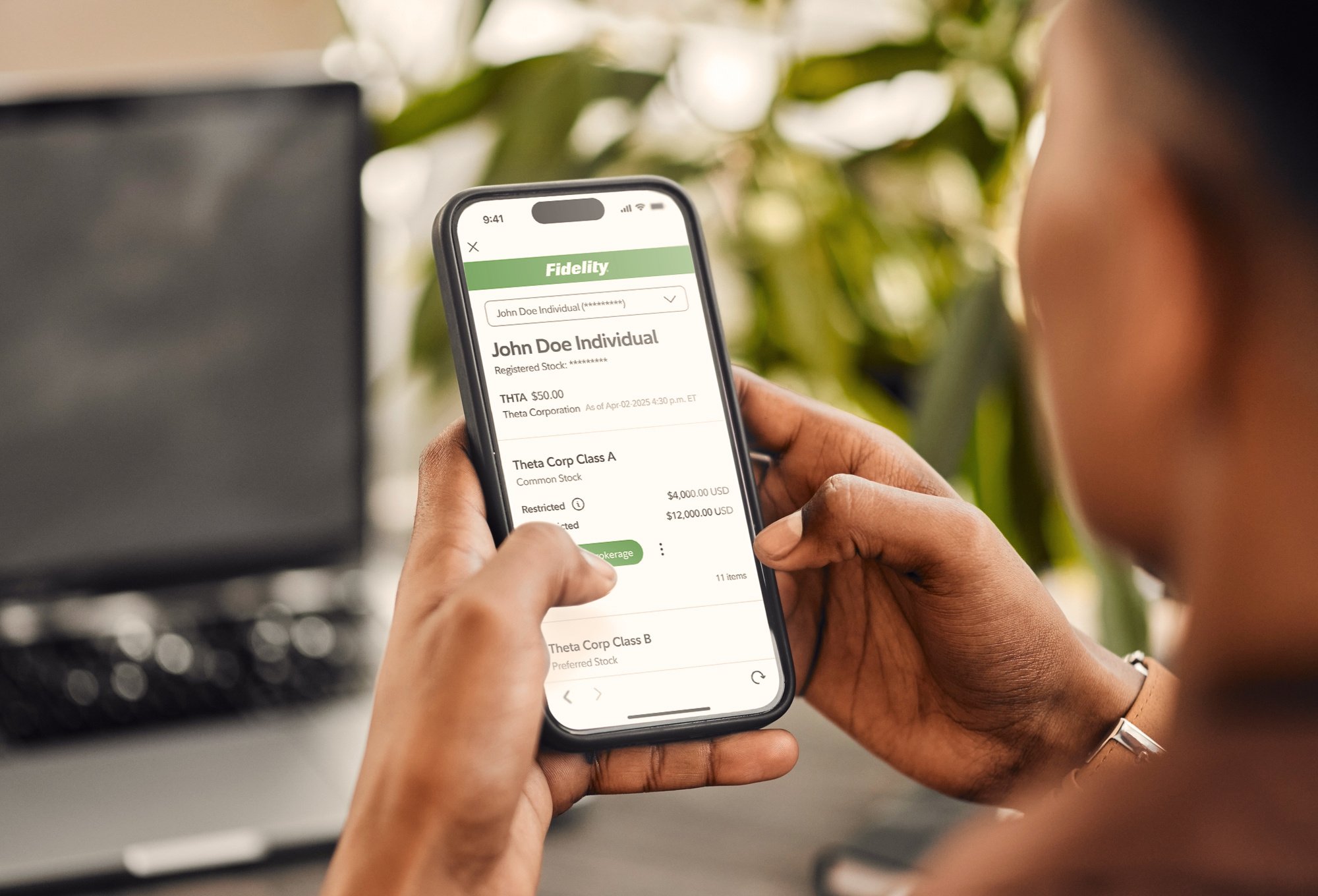 A photograph of a person viewing a Fidelity portfolio summary on their smart phone
